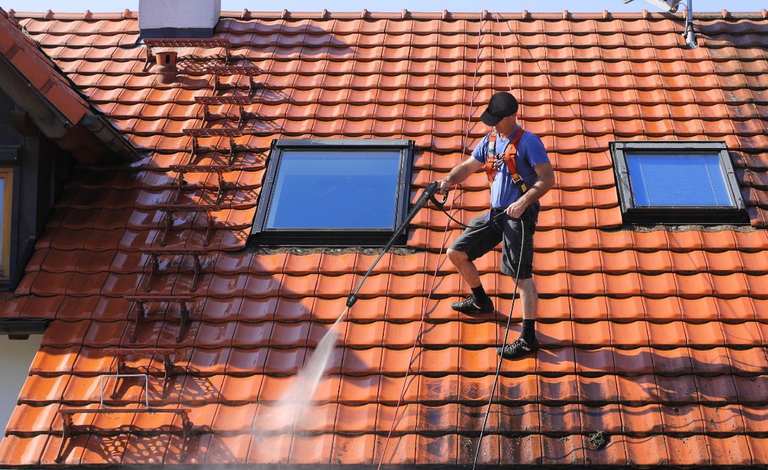 Osoba czyszcząca dach